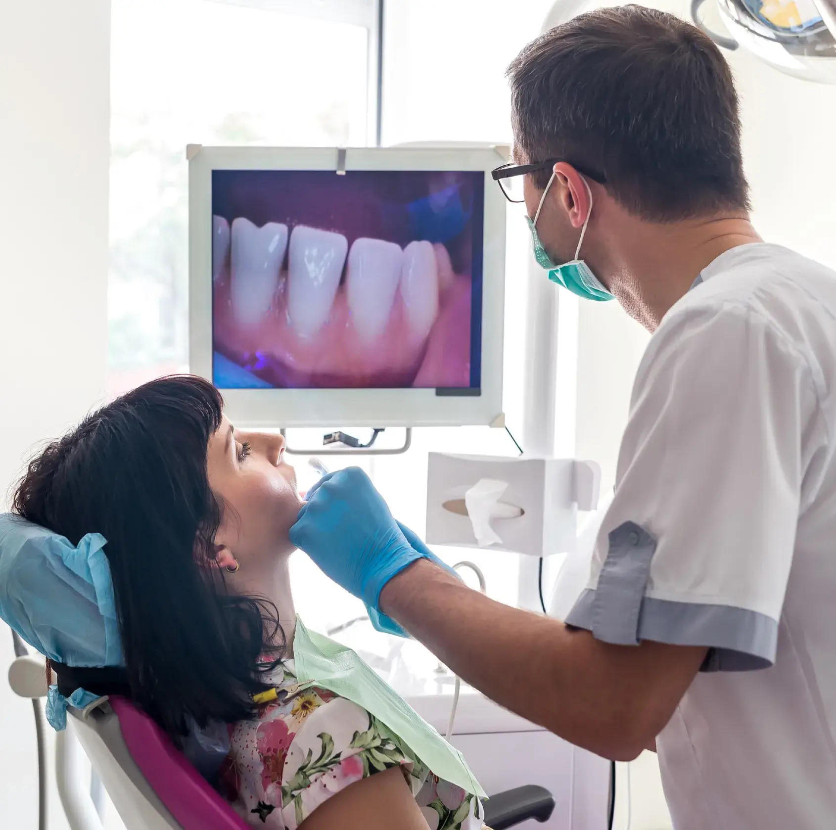 A woman getting her teeth checked by a dentist.