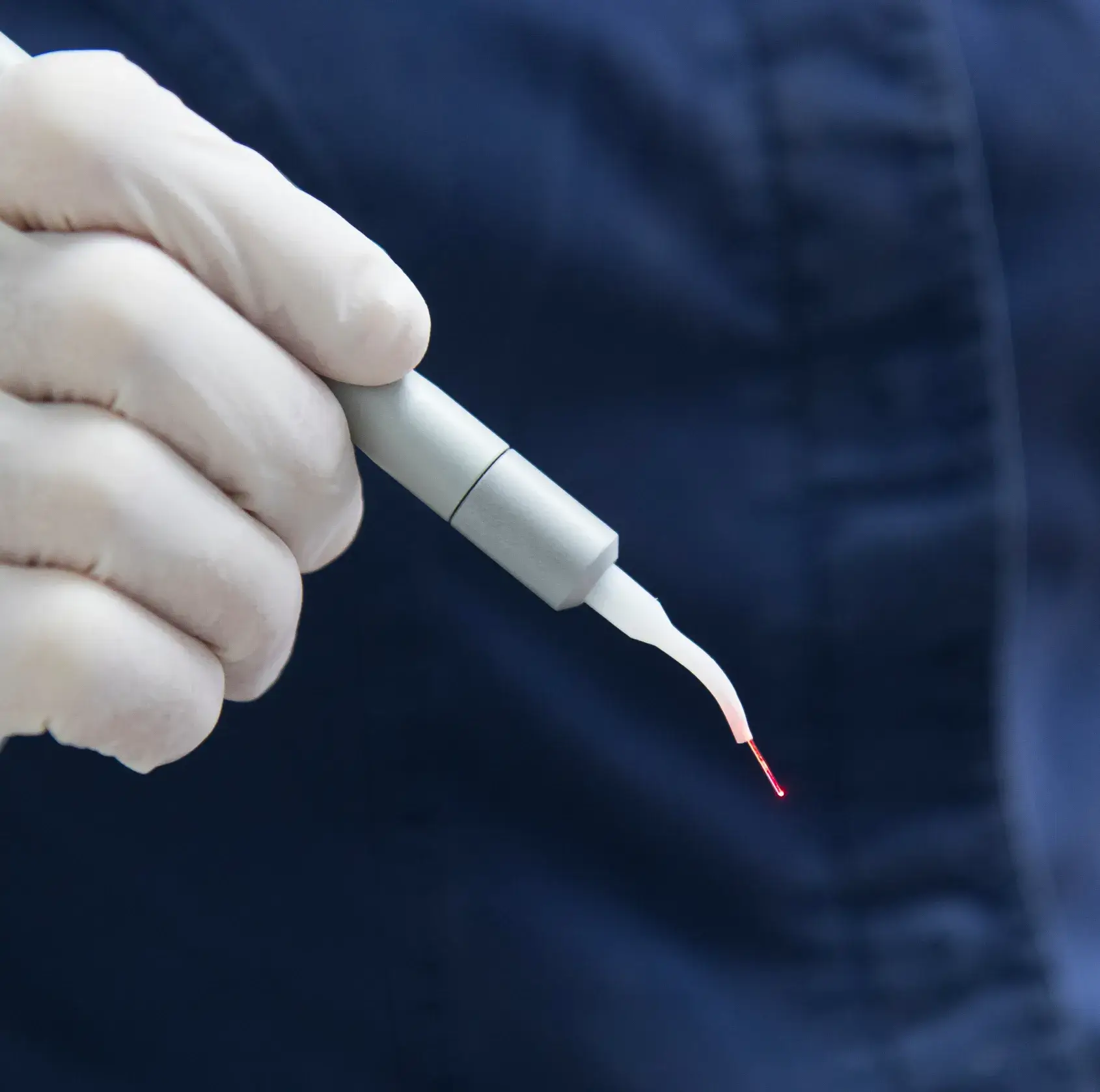 A person in white gloves is holding a white and red pen.